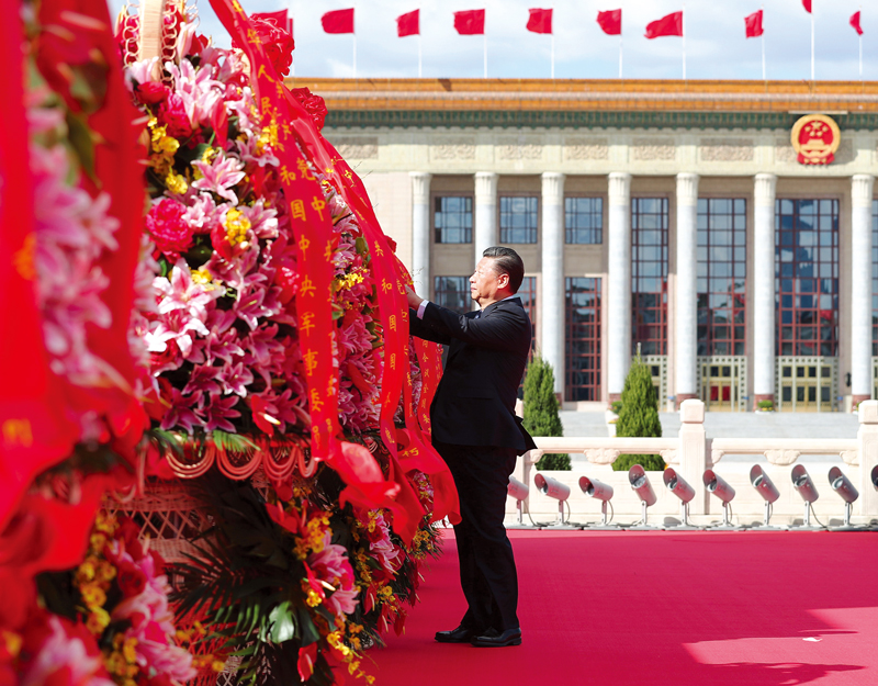 2018年9月30日上午，党和国家领导人习近平、李克强、栗战书、汪洋、王沪宁、赵乐际、韩正、王岐山等来到北京天安门广场，出席烈士纪念日向人民英雄敬献花篮仪式。这是习近平整理花篮上的缎带。 新华社记者 谢环驰/摄